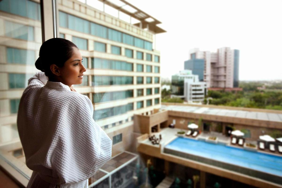 a woman looking out the window of a building at Crowne Plaza Today Gurugram by IHG in Gurgaon