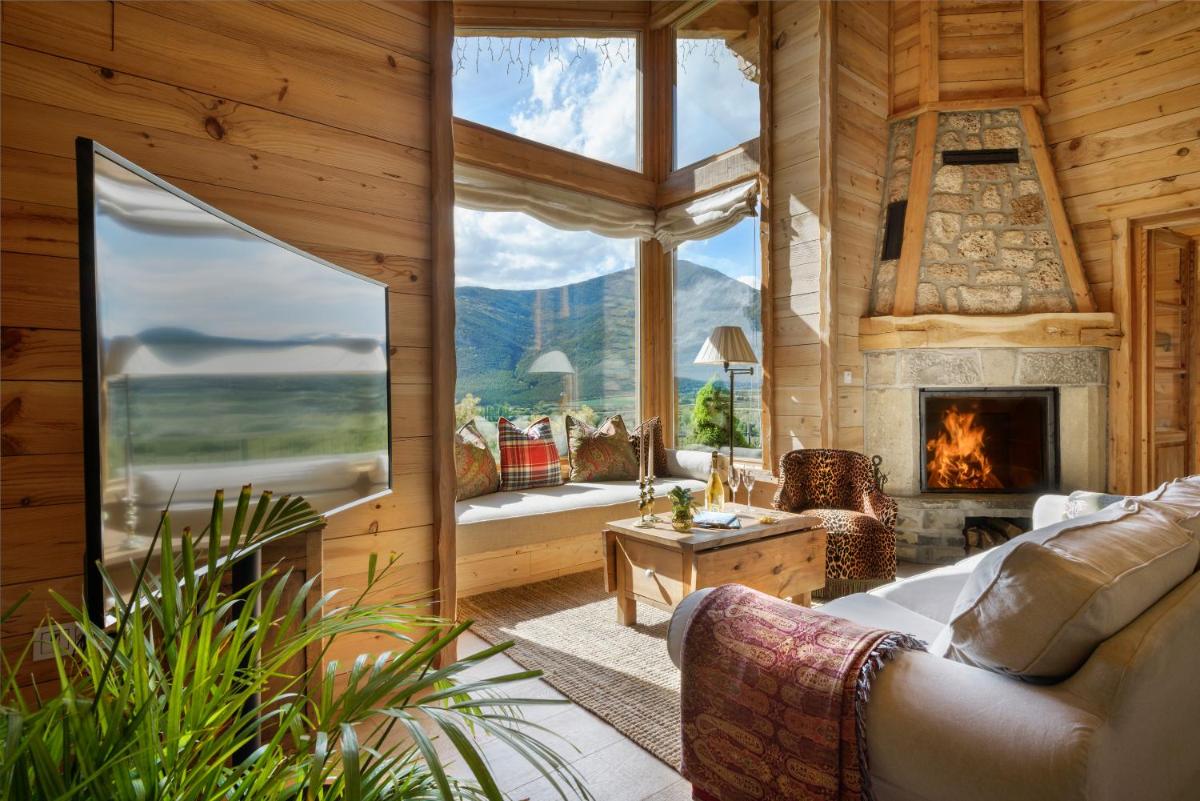 sala de estar con chimenea y ventana grande en Hotel Viñas de Lárrede, en Lárrede