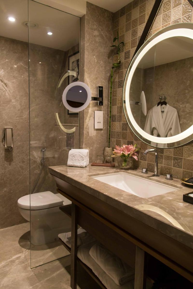 a bathroom with a sink and a mirror at Taj Bengal in Kolkata