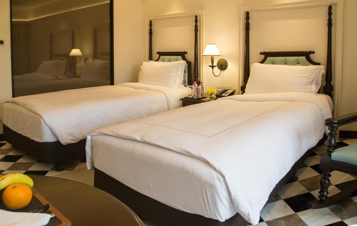 a hotel room with two beds and a table at Taj Bengal in Kolkata