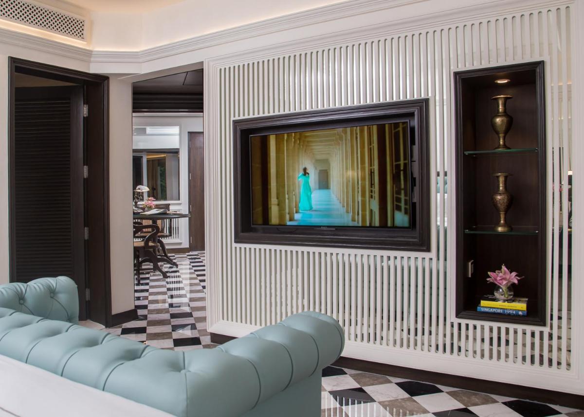 a living room with a blue couch and a television at Taj Bengal in Kolkata