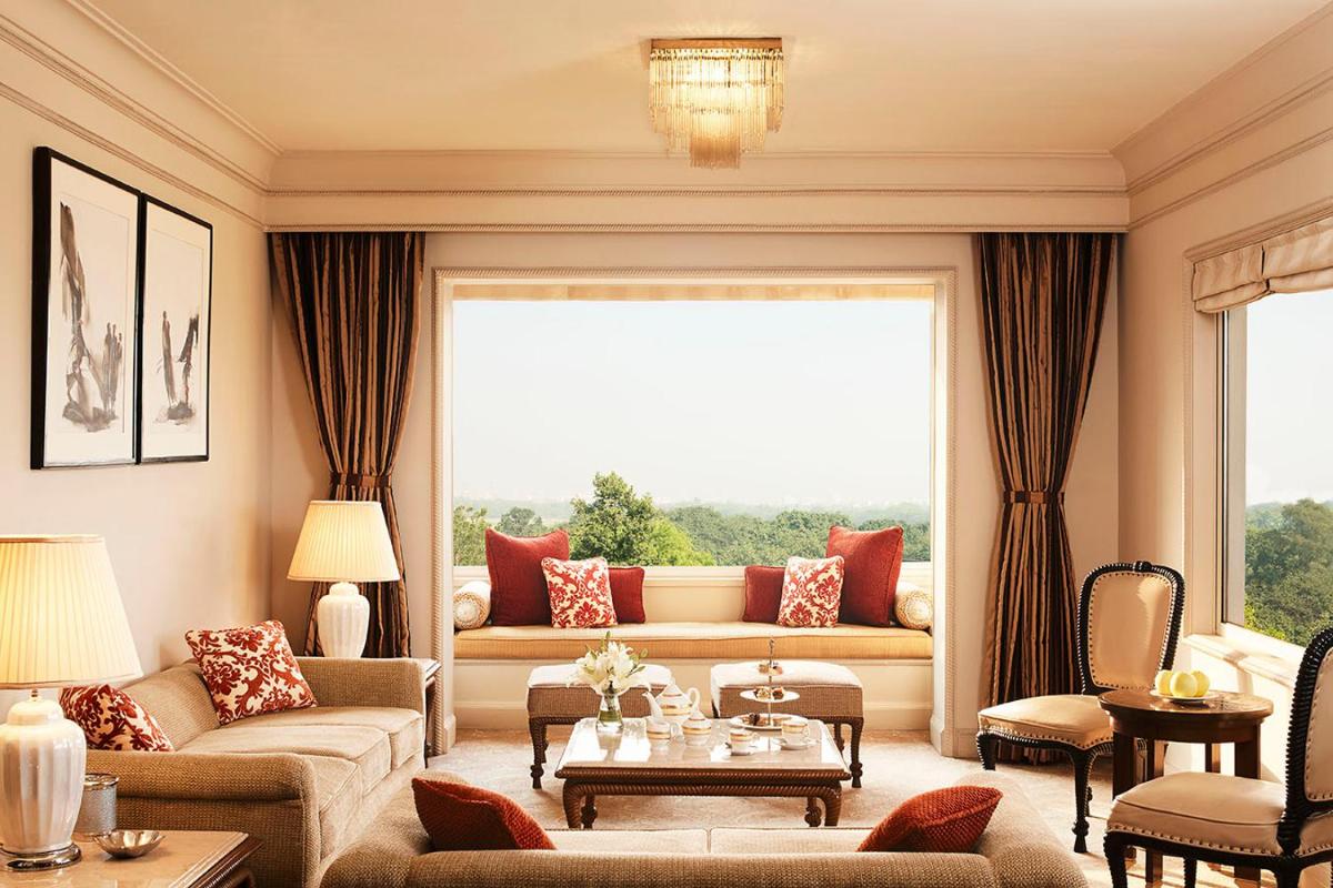 a living room with a couch and a large window at Taj Bengal in Kolkata