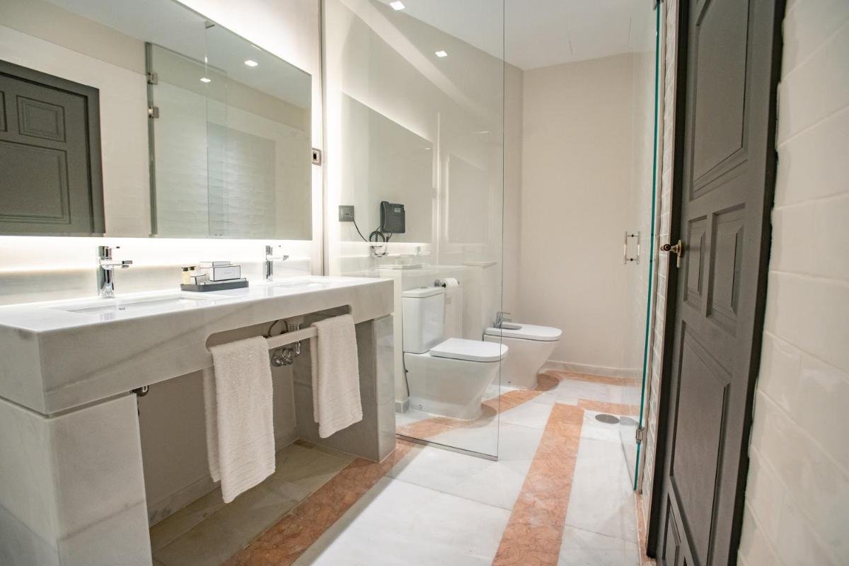 Un baño blanco con lavabo e inodoro. en Soho Boutique Castillo de Santa Catalina - Adults Recommended, en Málaga