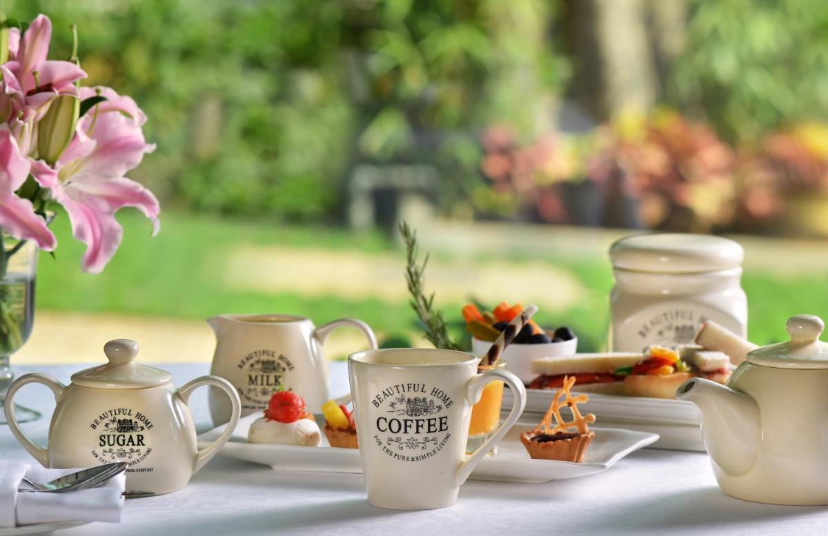 a table topped with cups and plates of food at Welcomhotel by ITC Hotels, Richmond Road, Bengaluru in Bengaluru