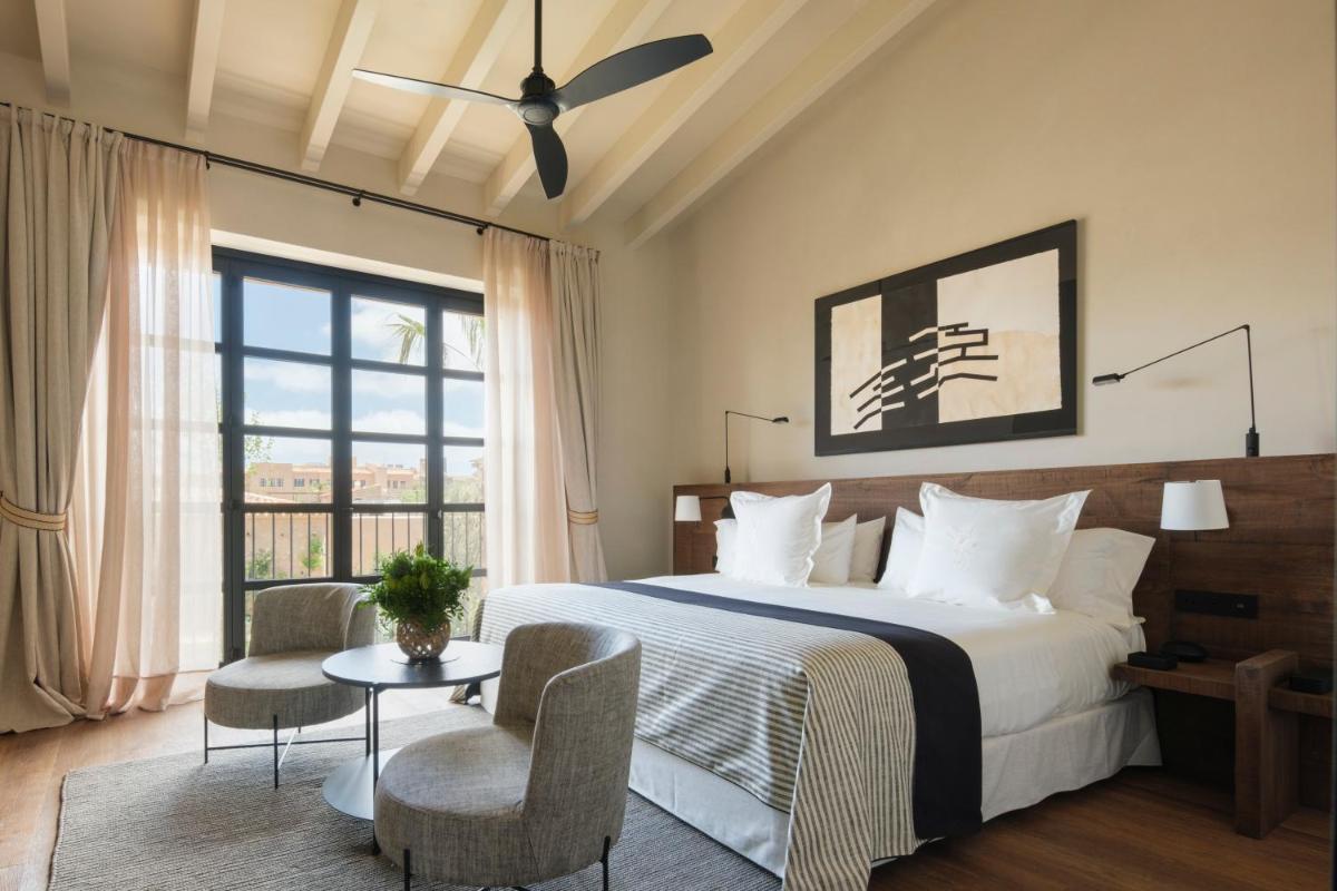 Un dormitorio con una cama y una ventana grande. en Can Ferrereta, en Santanyí