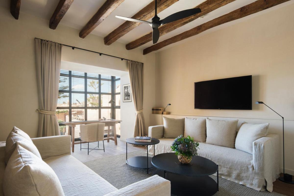 Una sala de estar con un sofá y un televisor. en Can Ferrereta, en Santanyí