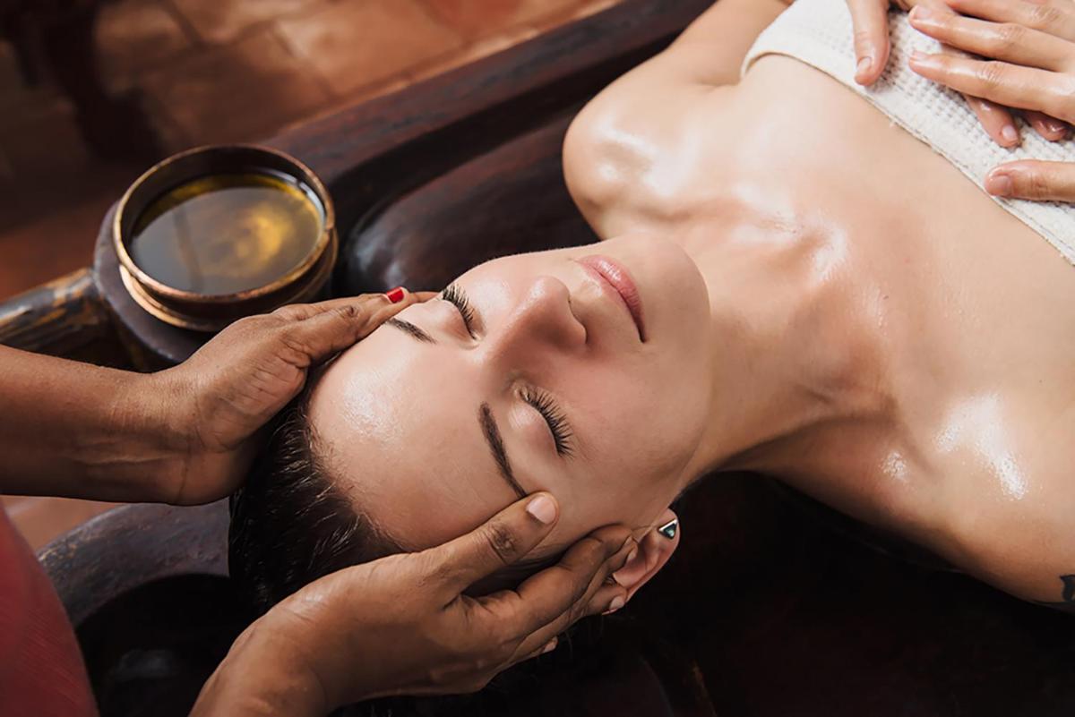 a woman getting a massage in a bathtub at Pilibhit House, Haridwar – IHCL SeleQtions in Haridwār