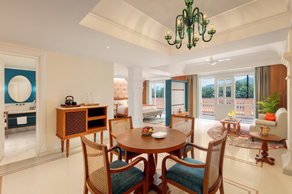 a living room with a dining room table and chairs at Pilibhit House, Haridwar – IHCL SeleQtions in Haridwār