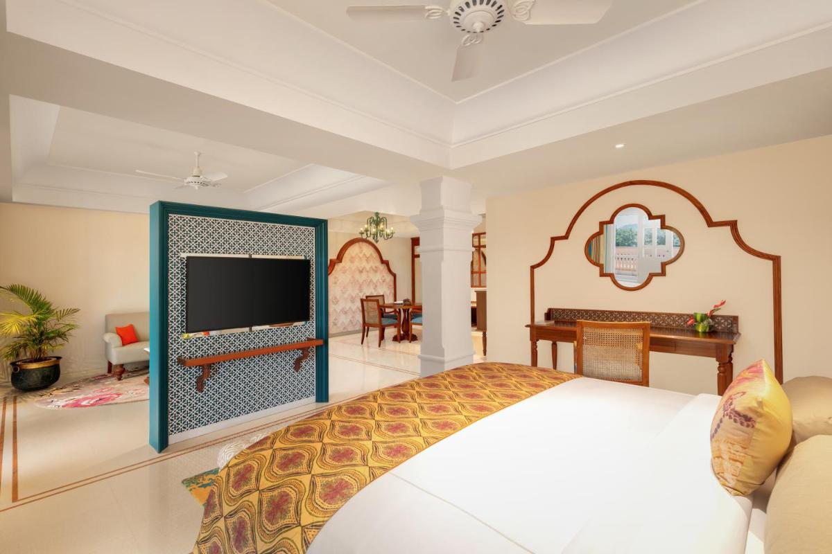 a bedroom with a bed and a flat screen tv at Pilibhit House, Haridwar – IHCL SeleQtions in Haridwār