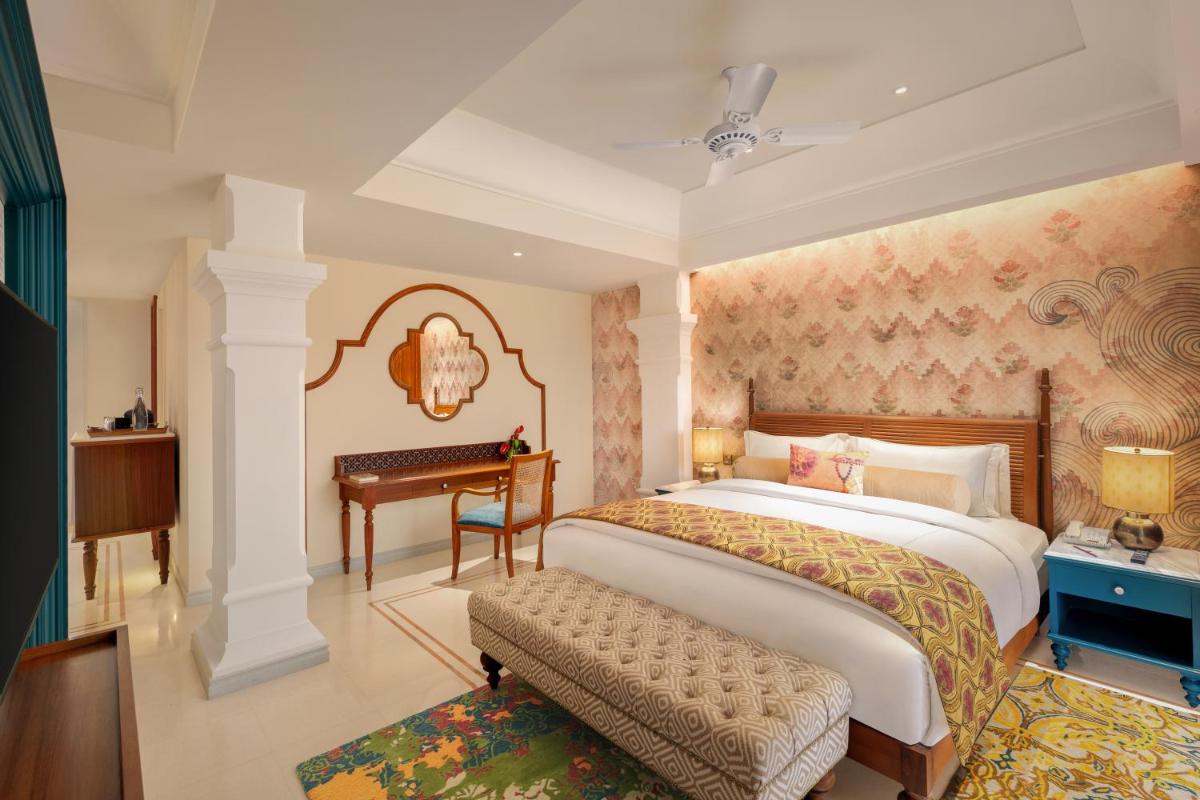 a bedroom with a large bed and a desk at Pilibhit House, Haridwar – IHCL SeleQtions in Haridwār