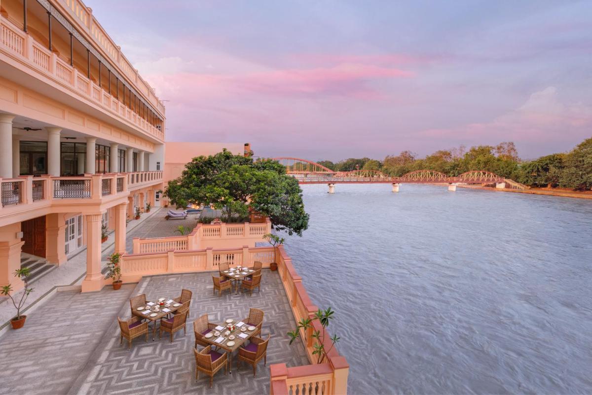 a view of a river from a hotel with tables and chairs at Pilibhit House, Haridwar – IHCL SeleQtions in Haridwār