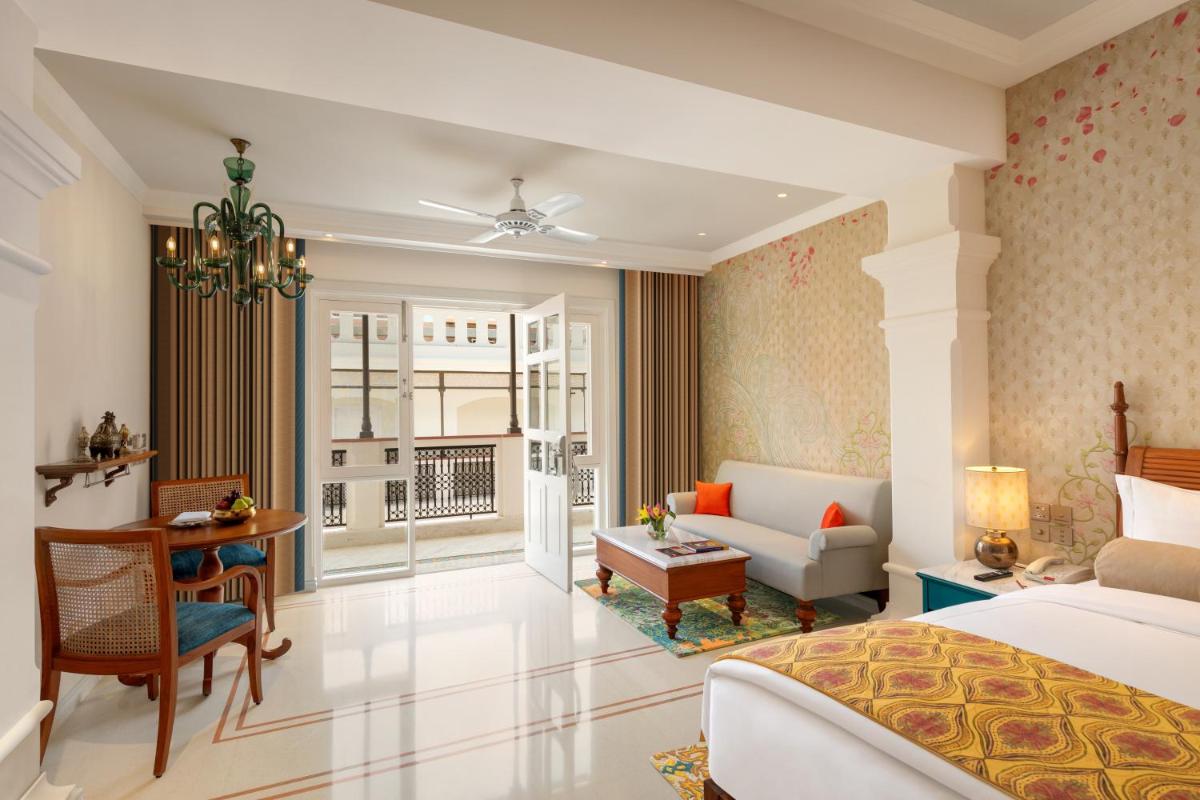 a bedroom with a bed and a living room at Pilibhit House, Haridwar – IHCL SeleQtions in Haridwār a bedroom with a bed and a living room at Pilibhit House, Haridwar – IHCL SeleQtions in Haridwār