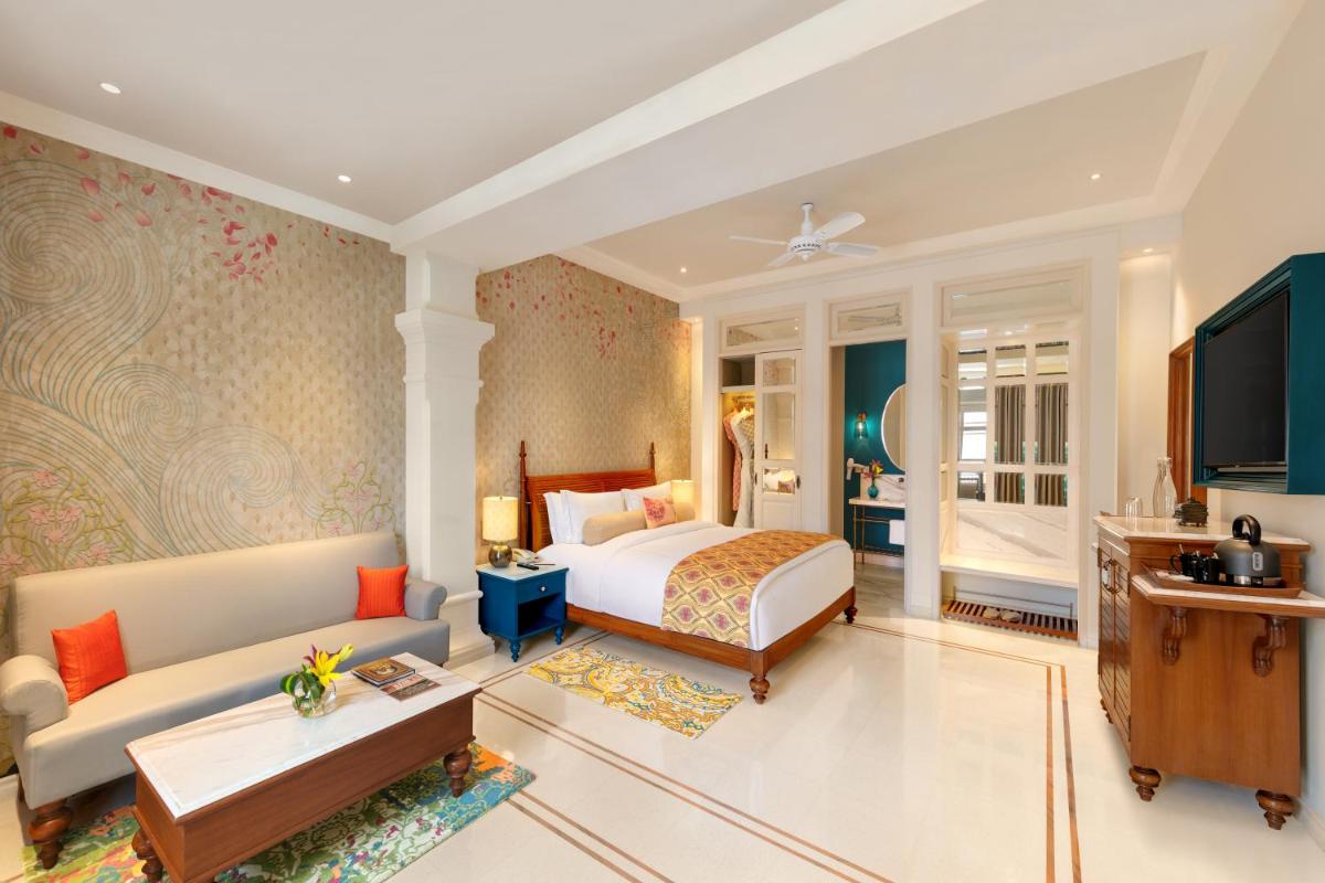 a hotel room with a bed and a couch at Pilibhit House, Haridwar – IHCL SeleQtions in Haridwār