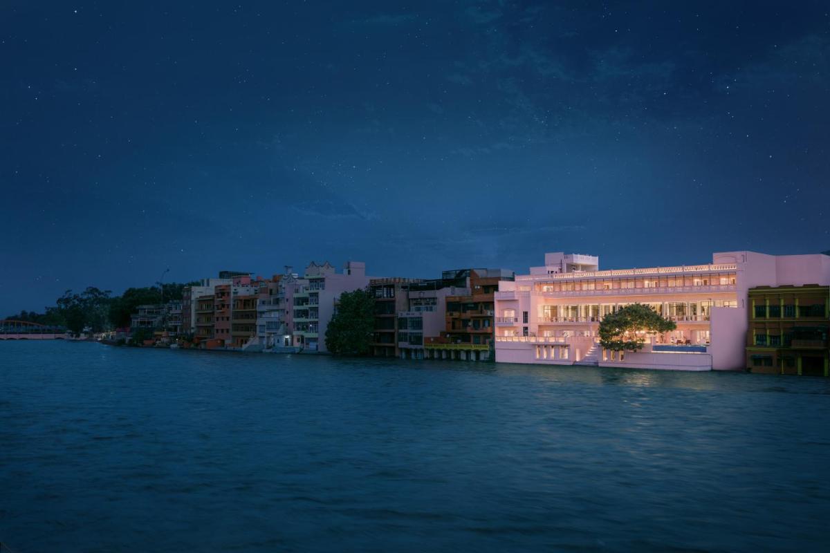a view of a river at night with buildings at Pilibhit House, Haridwar – IHCL SeleQtions in Haridwār