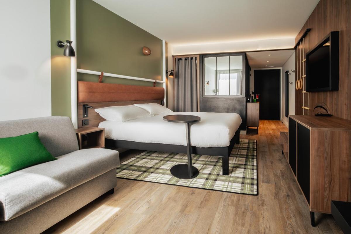 une chambre d'hôtel avec un lit et un canapé dans l'établissement ibis Styles Castelnaudary, à Castelnaudary