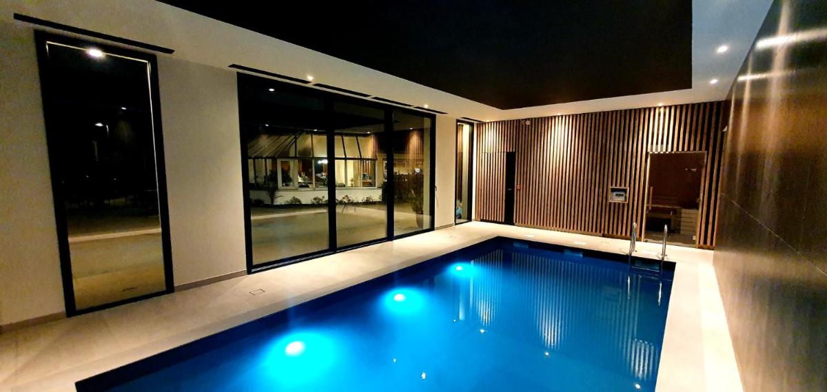 une piscine au milieu d'une maison dans l'établissement Best Western Armor Park Dinan et Spa, à Dinan