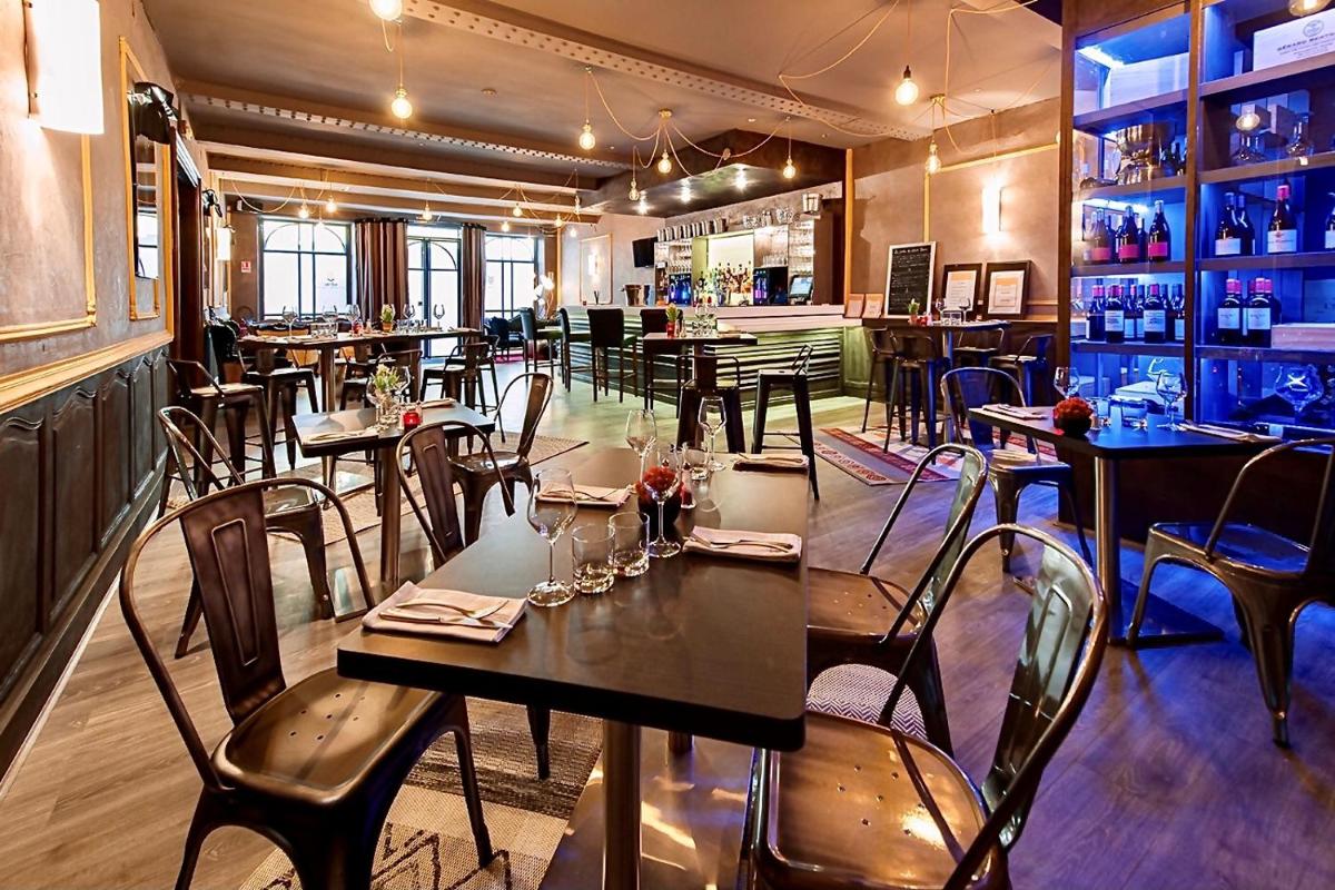 une salle à manger avec des tables et des chaises dans un restaurant dans l'établissement Hôtel Saint Louis, à Aigues-Mortes