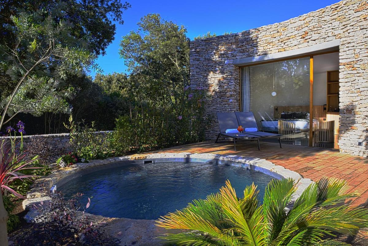 une piscine dans une cour avec un patio dans l'établissement A SPERANZA Suites avec piscine privative chauffée, à Bonifacio