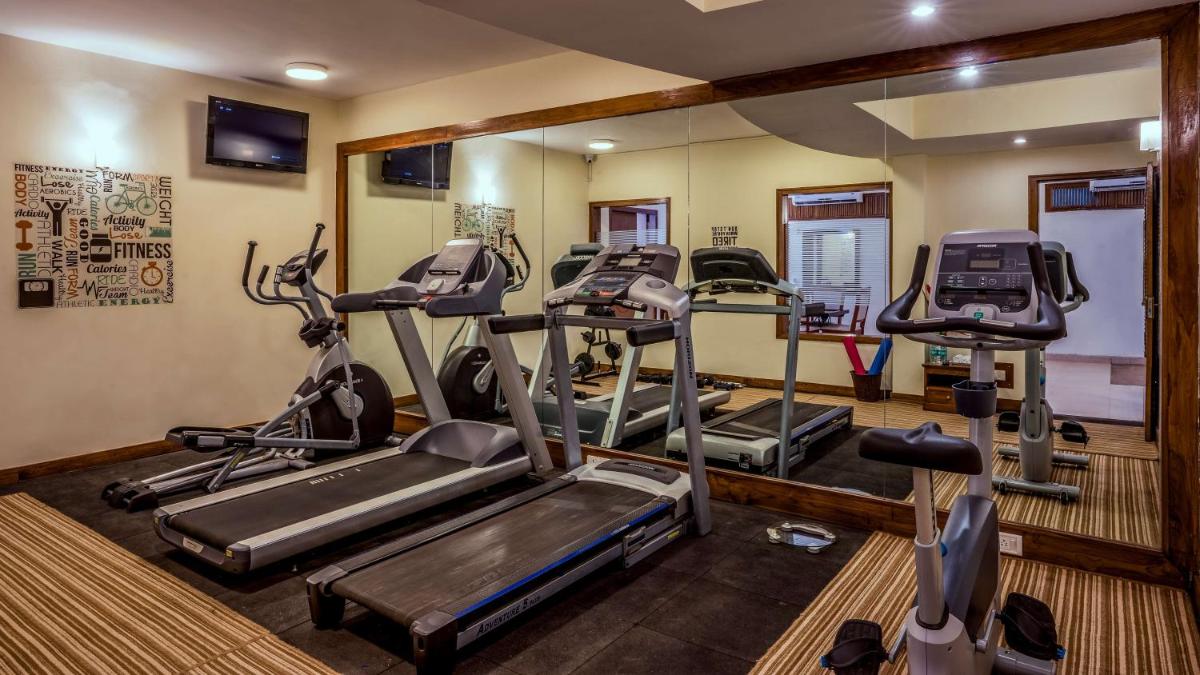 a gym with several tread machines in a room at Radisson Goa Candolim in Candolim