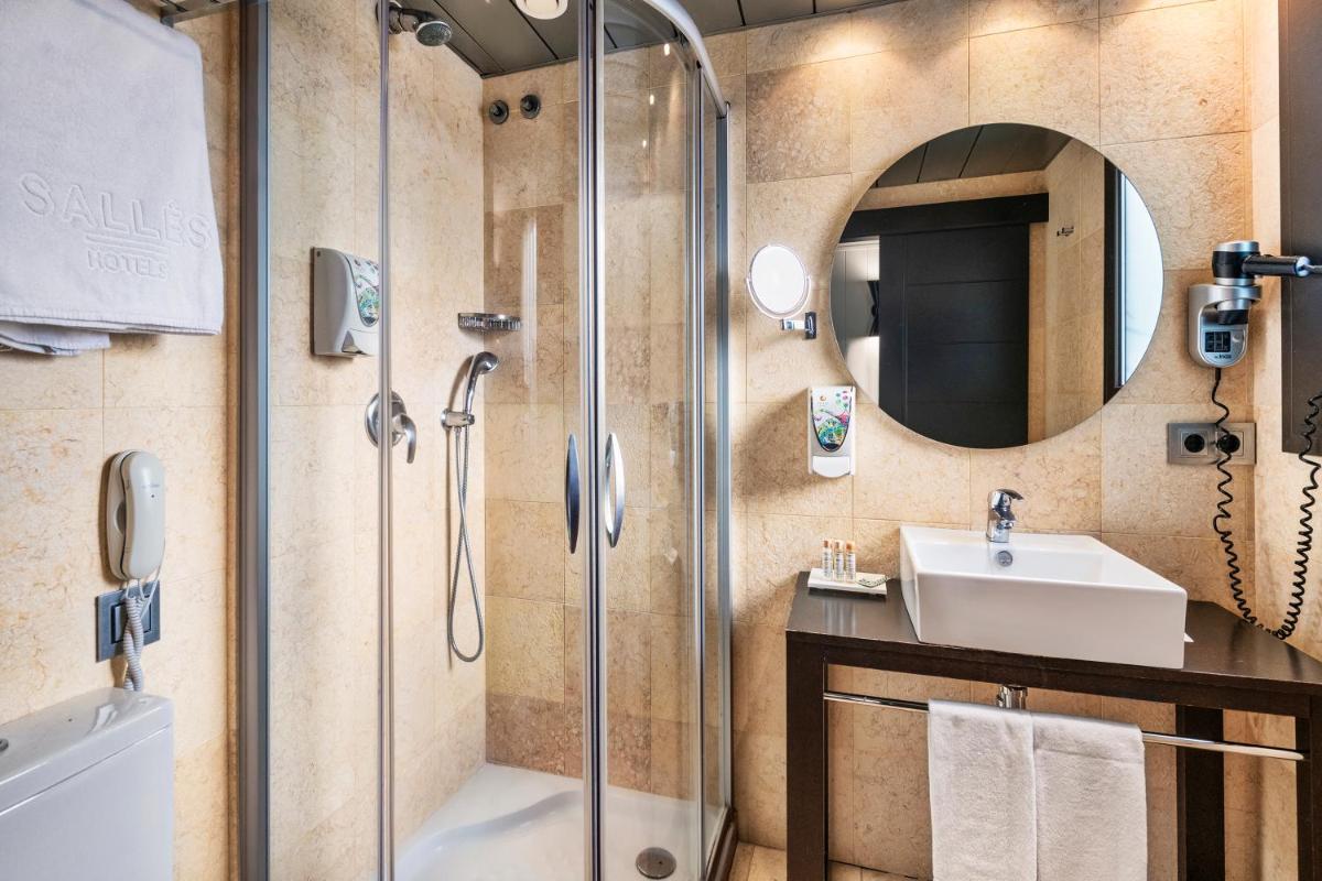 un baño con ducha y lavabo en Salles Hotel Aeroport de Girona, en Riudellots de la Selva