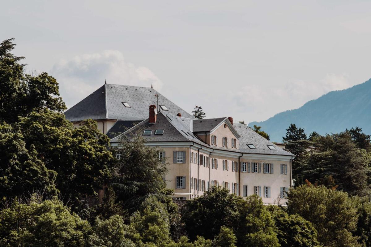 une grande maison au sommet d'une colline avec des arbres dans l'établissement Hôtel La Robéyère - BW Signature Collection, à Embrun
