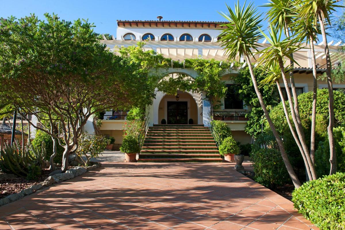 una entrada a una casa con palmeras y escaleras en Hotel Bahia, en Paguera