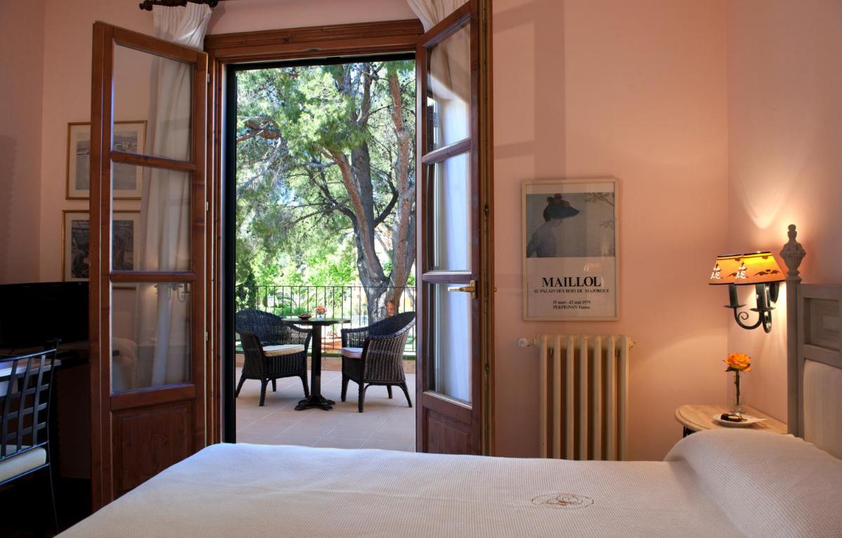 1 dormitorio con 1 cama y puerta abierta a un patio en Hotel Bahia, en Paguera