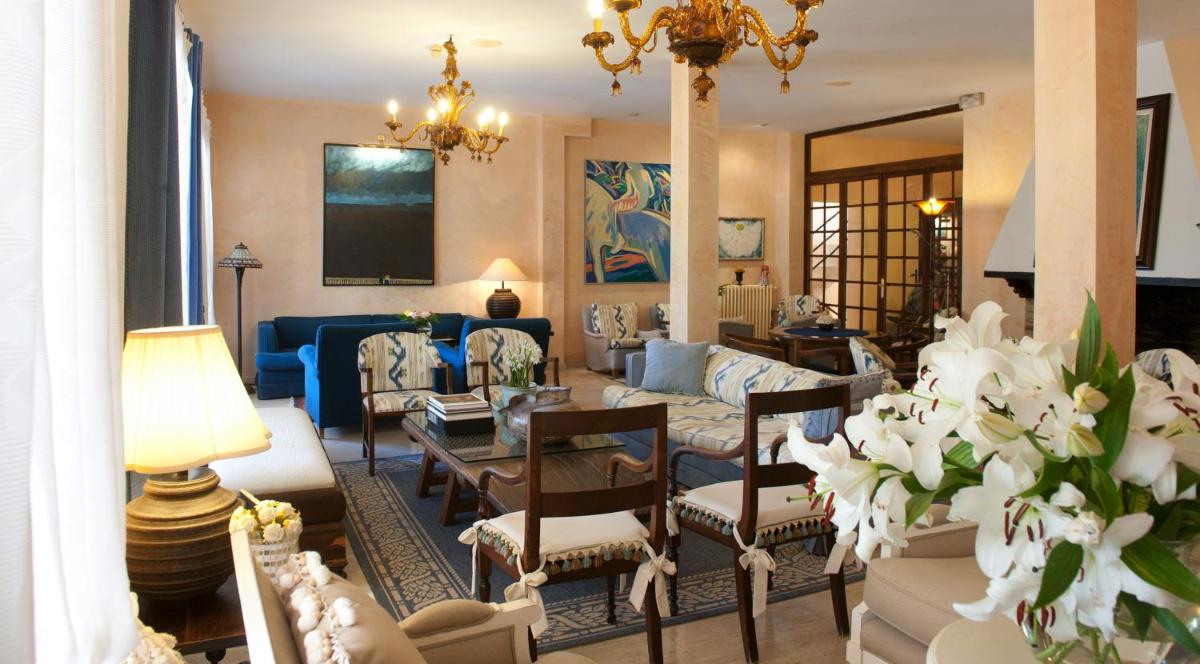 Una sala de estar con un sofá, una mesa y sillas. en Hotel Bahia, en Paguera