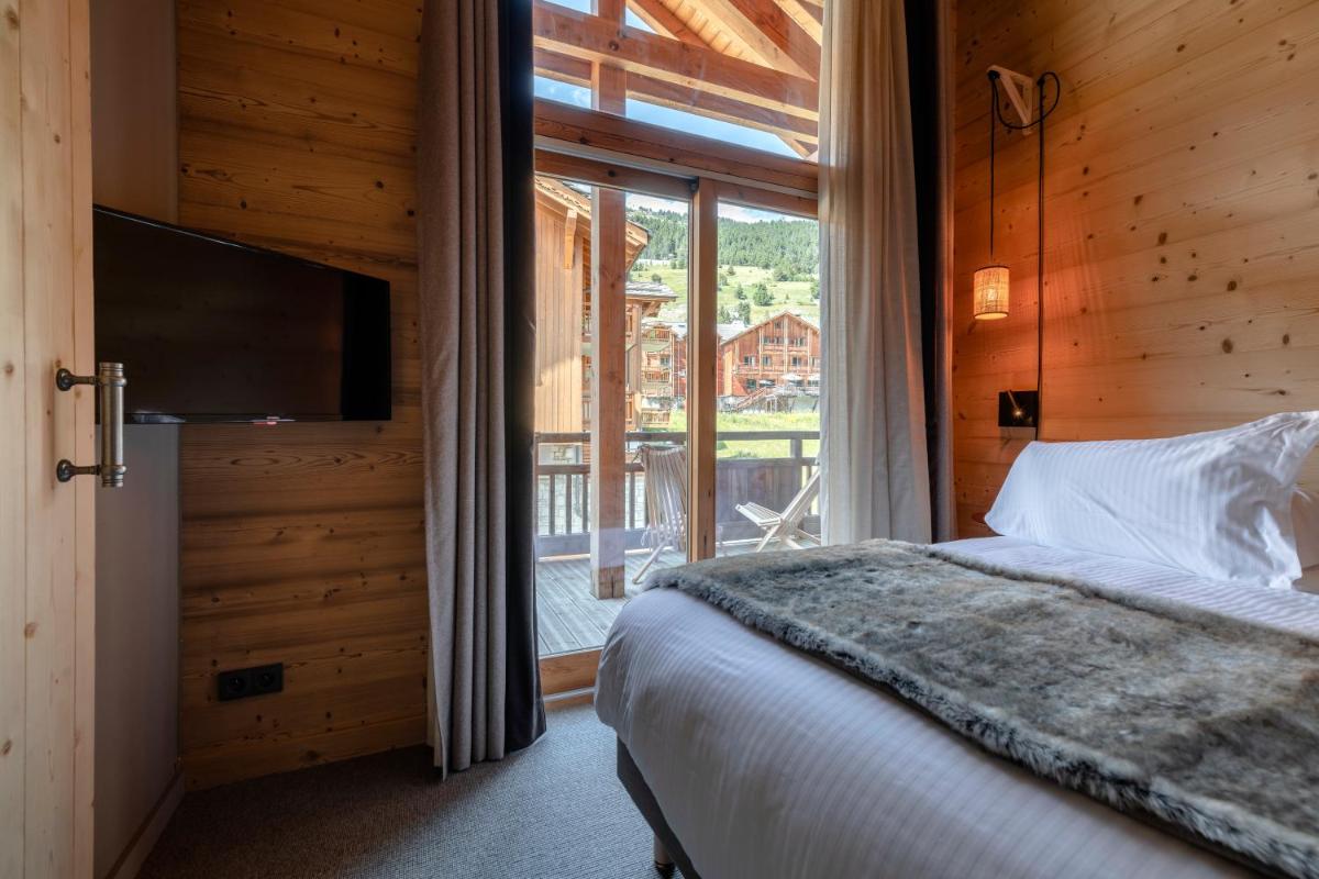 Un ou plusieurs lits dans un hébergement de l'établissement Le Chalet Blanc Hôtel & Spa
