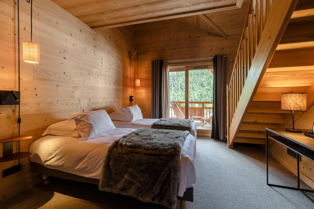 Un ou plusieurs lits dans un hébergement de l'établissement Le Chalet Blanc Hôtel & Spa