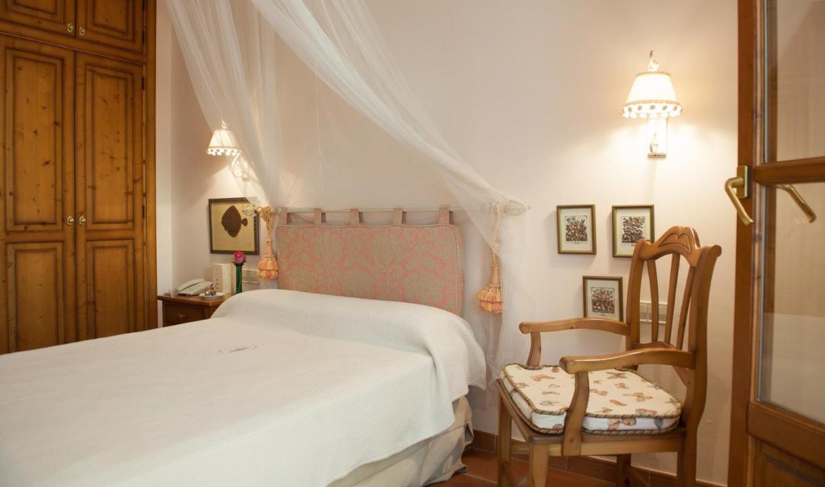 Un dormitorio con una cama blanca y una silla. en Hotel Bahia, en Paguera 34 fotos más