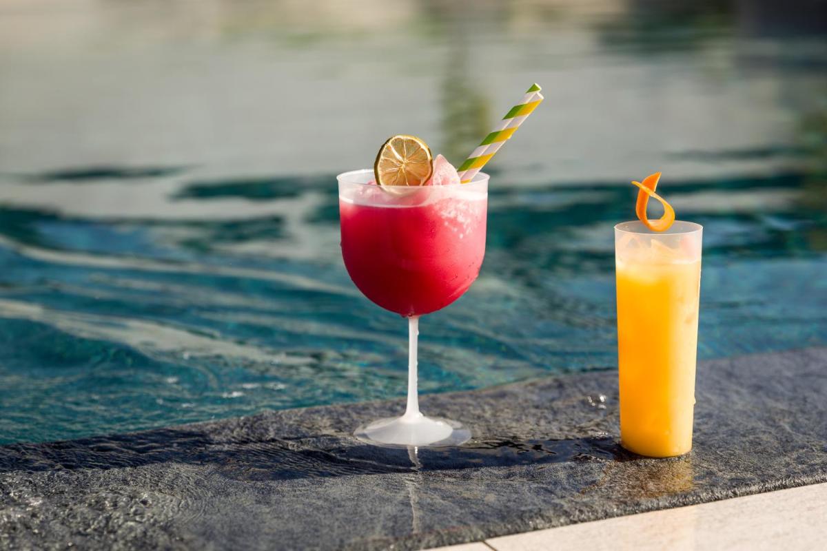 Dois cocktails numa mesa ao lado de uma piscina em Hotel Do Parque - Congress & SPA nas Termas de São Pedro do Sul