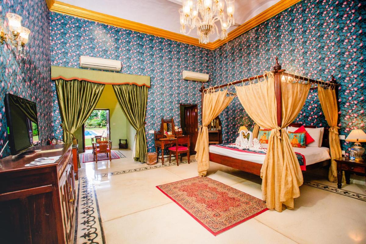 a bedroom with a canopy bed and blue wallpaper at The Grand Imperial - Heritage Hotel in Agra