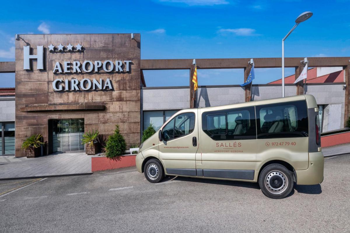 Una camioneta blanca estacionada frente a un edificio en Salles Hotel Aeroport de Girona, en Riudellots de la Selva