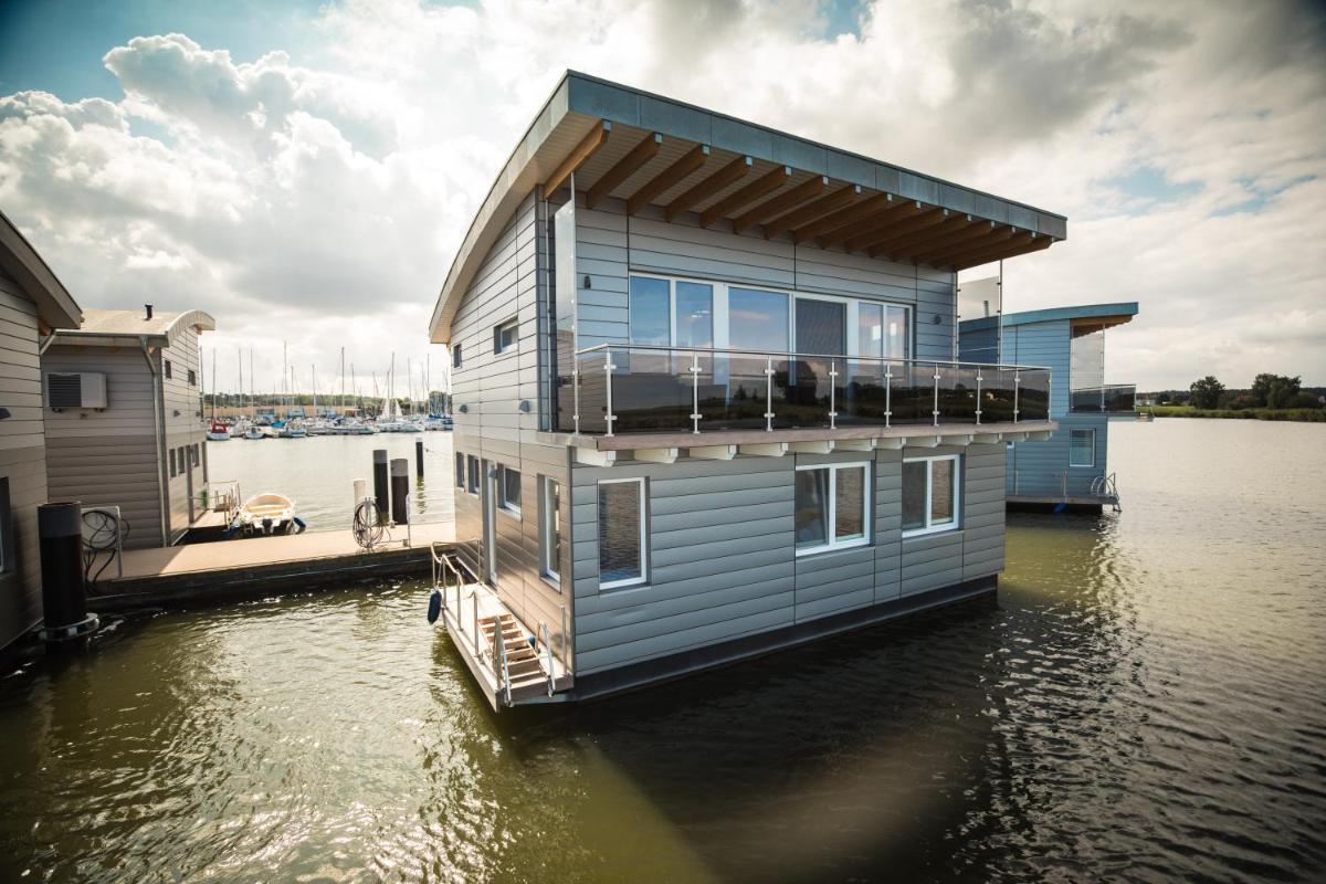 ein Haus auf einem Steg an einem Gewässer in der Unterkunft Schwimmende Häuser im BALTIC SEA RESORT in Kröslin
