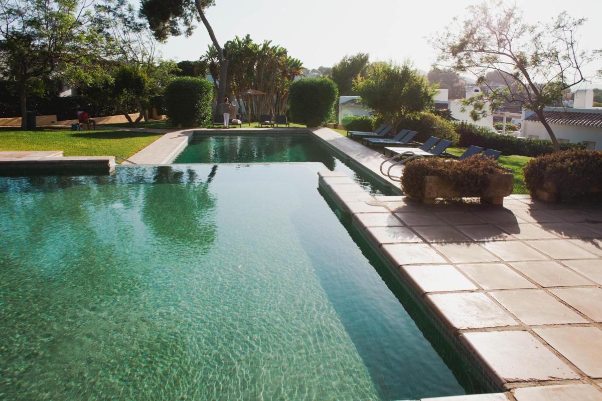 Una piscina en un patio con sillas y árboles. en Hotel Ritual de Terra & SPA, en Jávea
