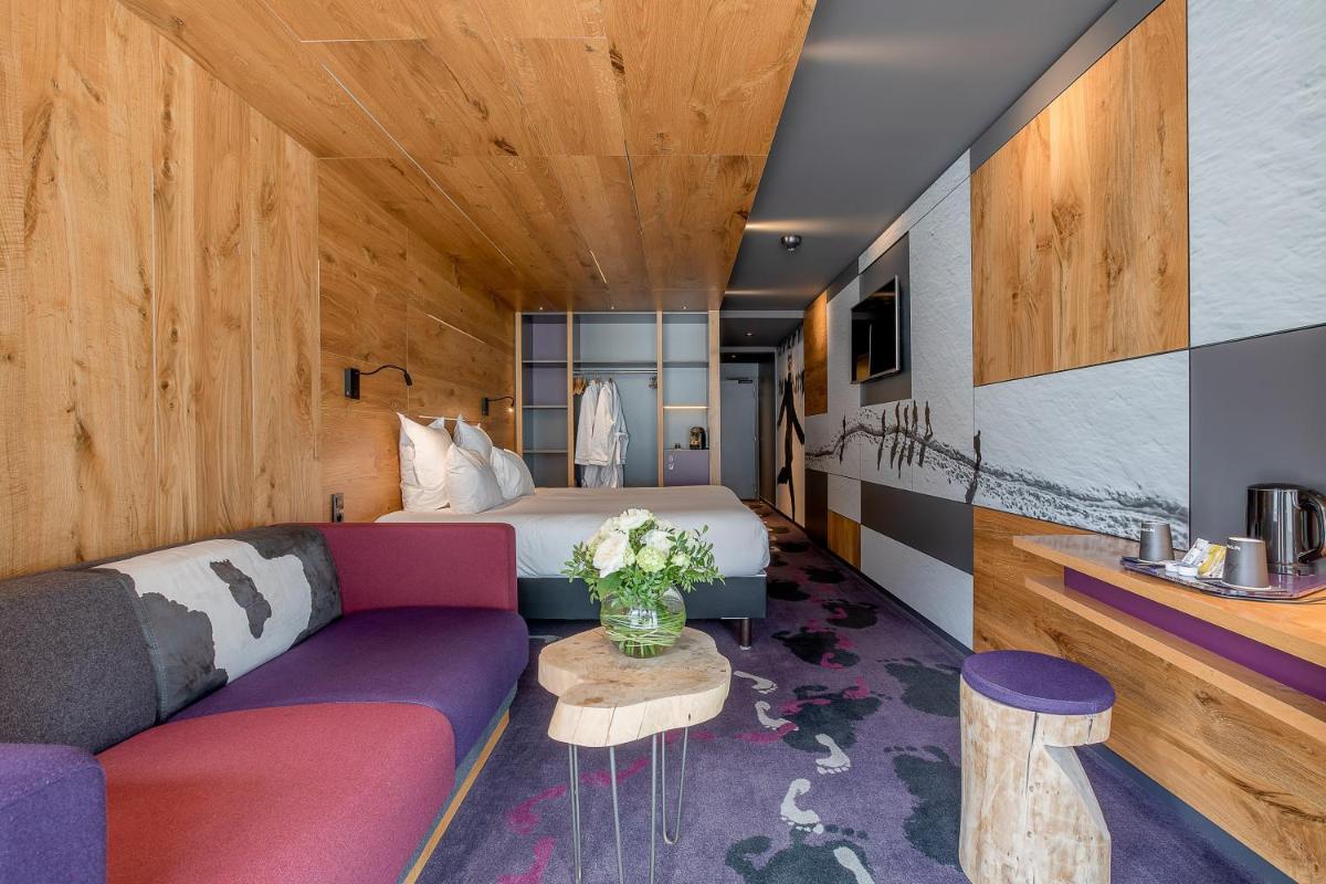 une chambre d'hôtel avec un lit et un canapé dans l'établissement Alpina Eclectic Hotel, à Chamonix-Mont-Blanc