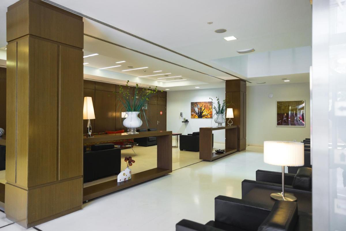vestíbulo de un hotel con sofás y escritorio en Hotel Veracruz Plaza & Spa, en Valdepeñas