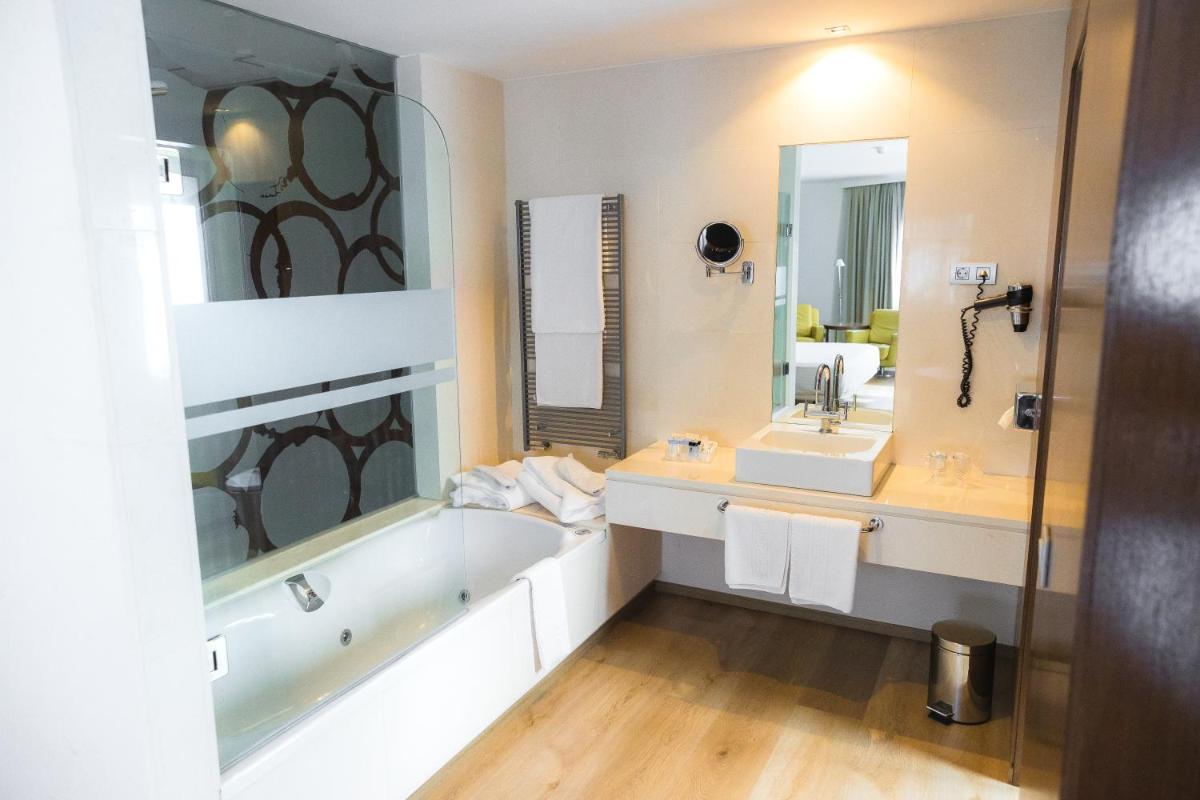 Un baño con bañera, lavabo y bañera. en Hotel Veracruz Plaza & Spa, en Valdepeñas