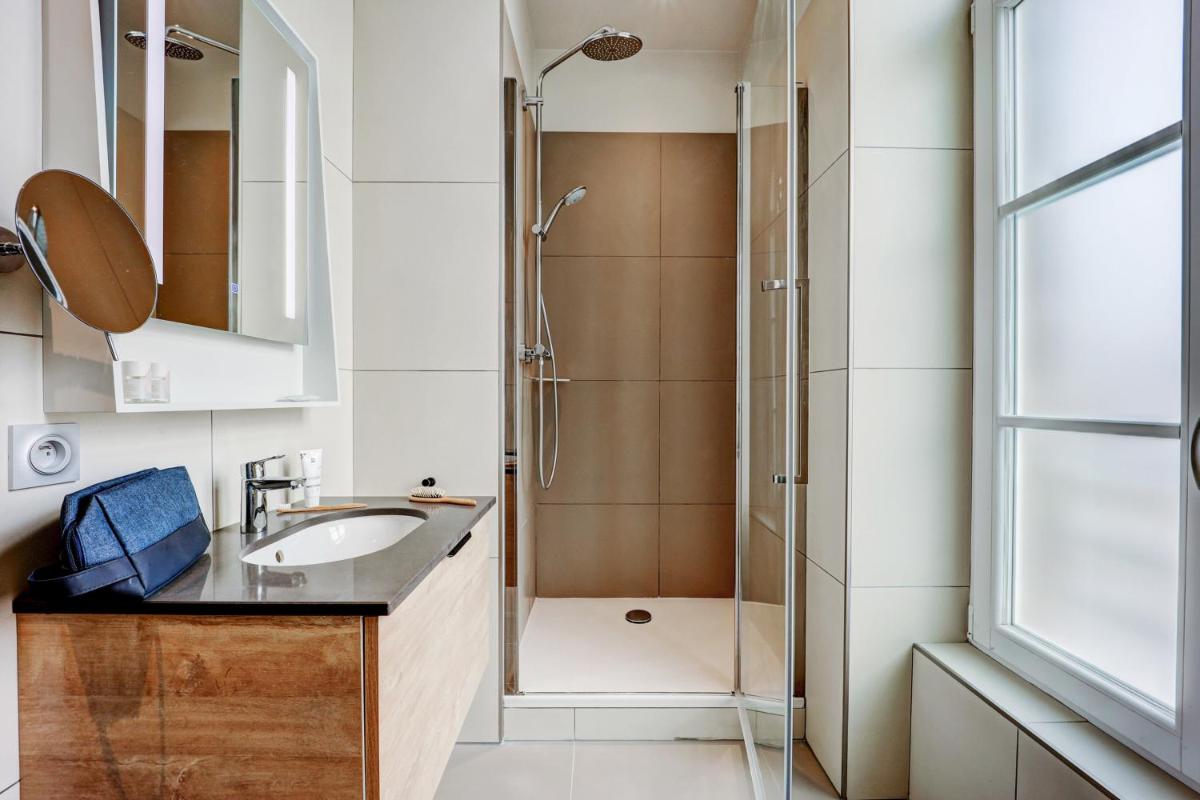 une salle de bain avec lavabo et douche dans l'établissement Résidence Pierre & Vacances Premium Presqu'Ile de la Touques, à Deauville