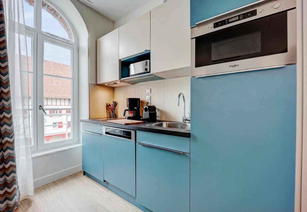 - un réfrigérateur bleu dans la cuisine avec une fenêtre dans l'établissement Résidence Pierre & Vacances Premium Presqu'Ile de la Touques, à Deauville 103 autres photos