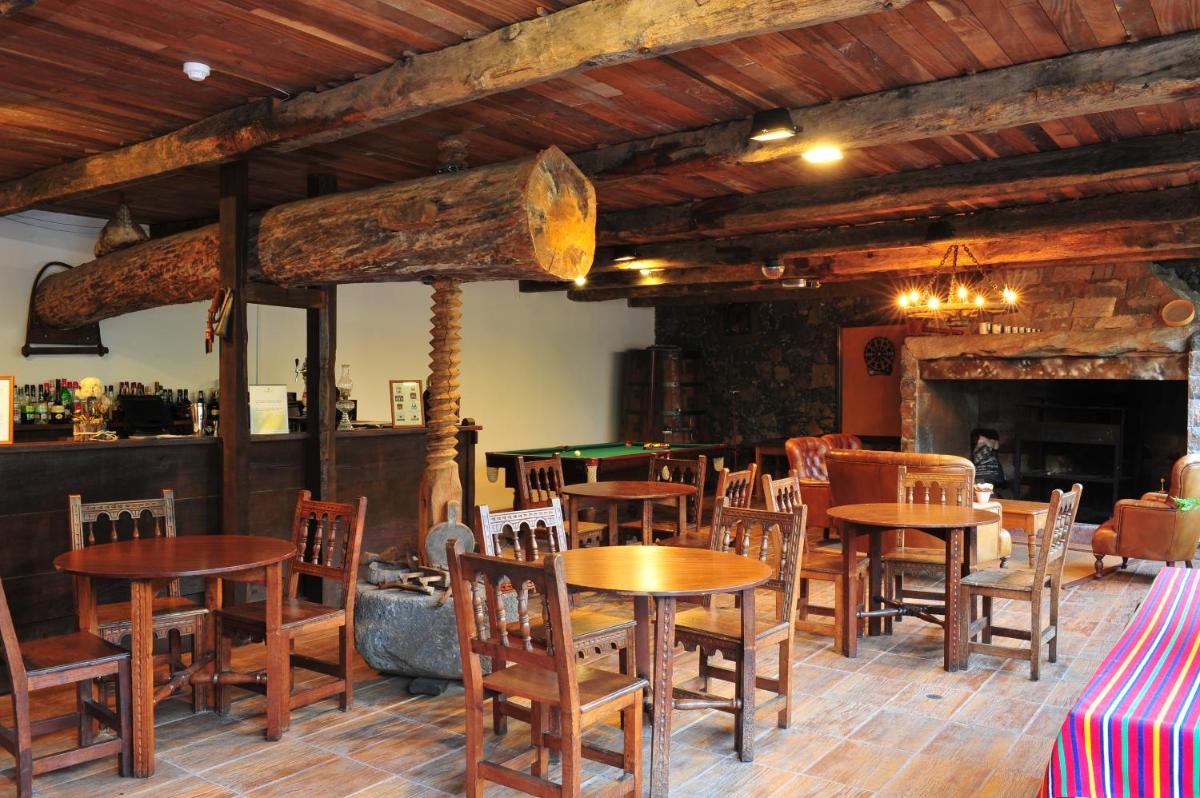 um restaurante com mesas e cadeiras e uma mesa de bilhar em Estalagem do Vale em São Vicente