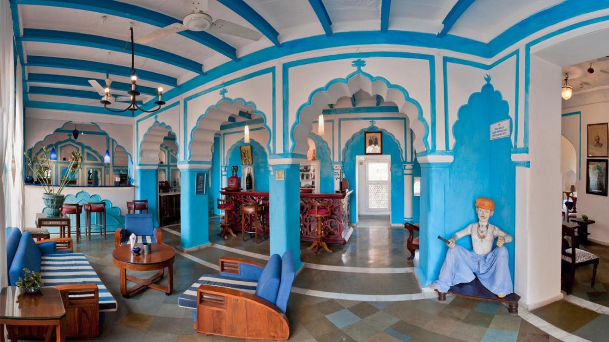 a large room with blue walls and furniture in a building at Neemrana Fort-Palace in Neemrana