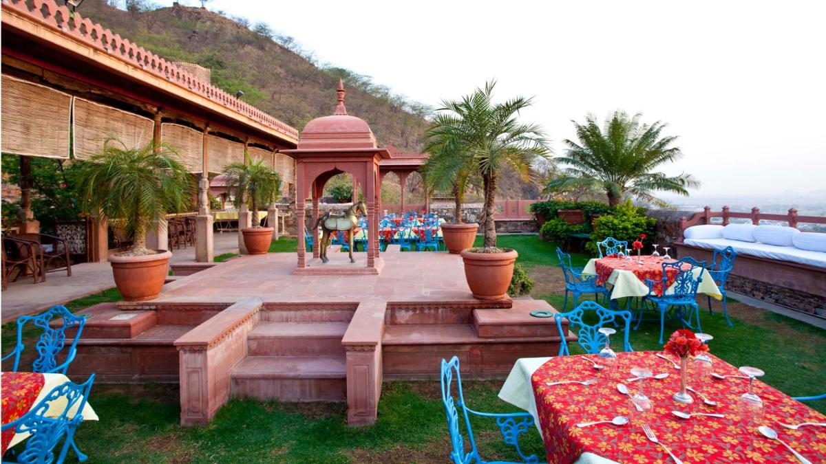 a patio with tables and chairs and a fountain at Neemrana Fort-Palace in Neemrana