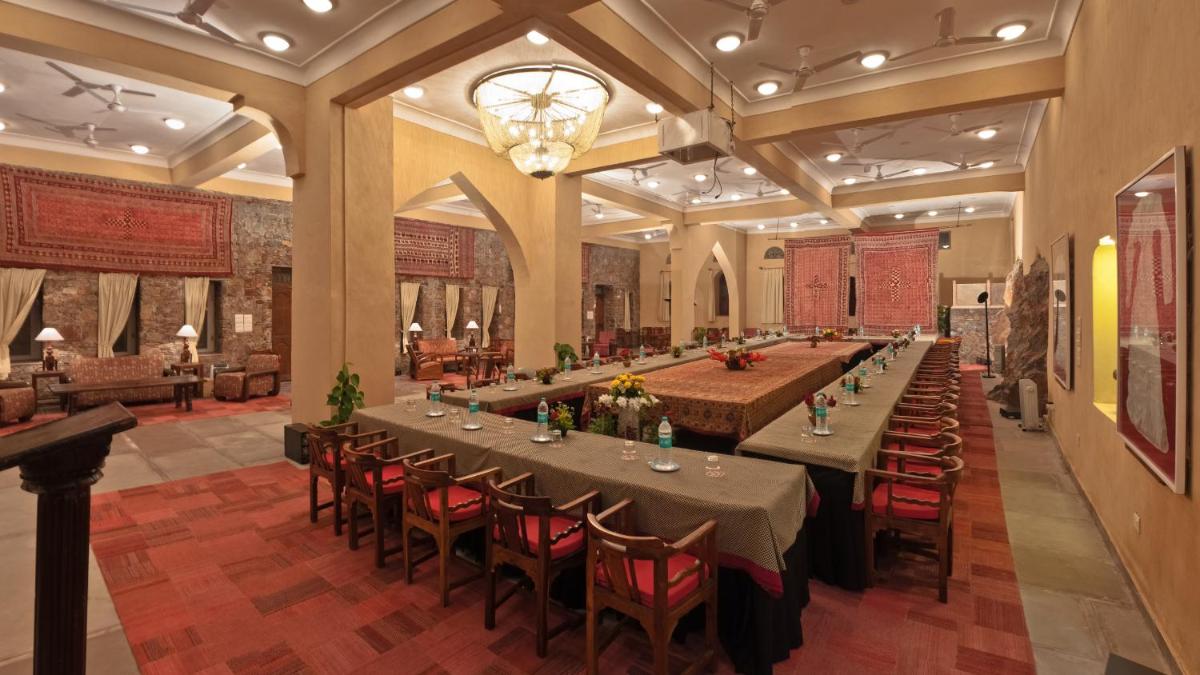 a large banquet hall with long tables and chairs at Neemrana Fort-Palace in Neemrana