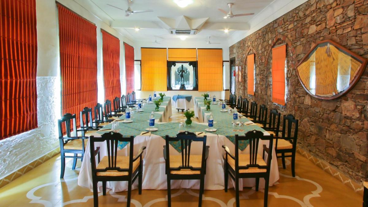 a long dining room with a long table and chairs at Neemrana Fort-Palace in Neemrana