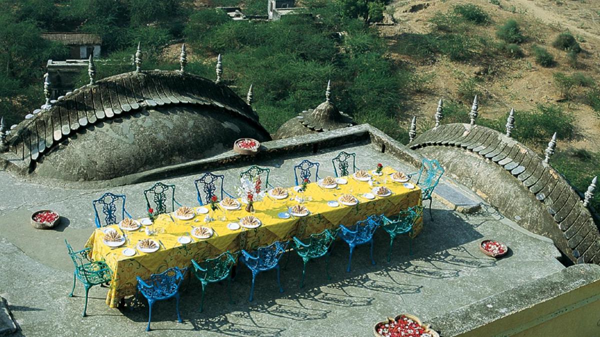 a table with a yellow and blue table cloth at Neemrana Fort-Palace in Neemrana