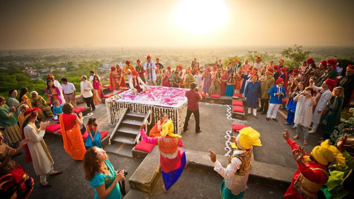 a large crowd of people watching a wedding ceremony at Neemrana Fort-Palace in Neemrana
