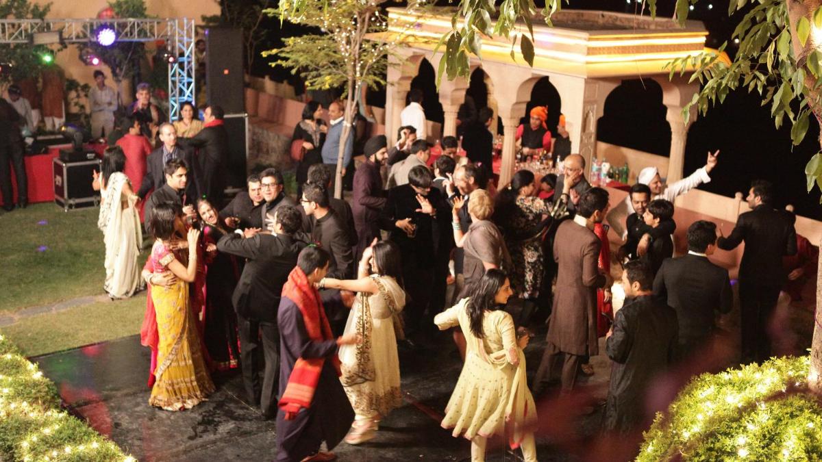 a group of people dancing at a wedding reception at Neemrana Fort-Palace in Neemrana
