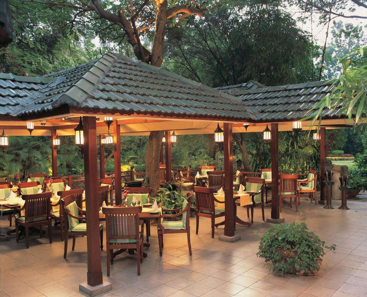 a restaurant with tables and chairs under a pavilion at The Oberoi Bengaluru in Bengaluru a restaurant with tables and chairs under a pavilion at The Oberoi Bengaluru in Bengaluru